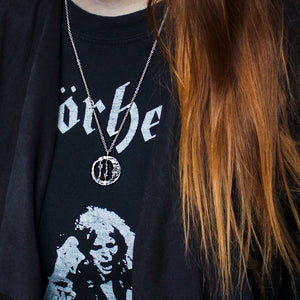 Moon and star necklace in round shape, made of silver. Shown on a woman wearing a motörhead t-shirt.